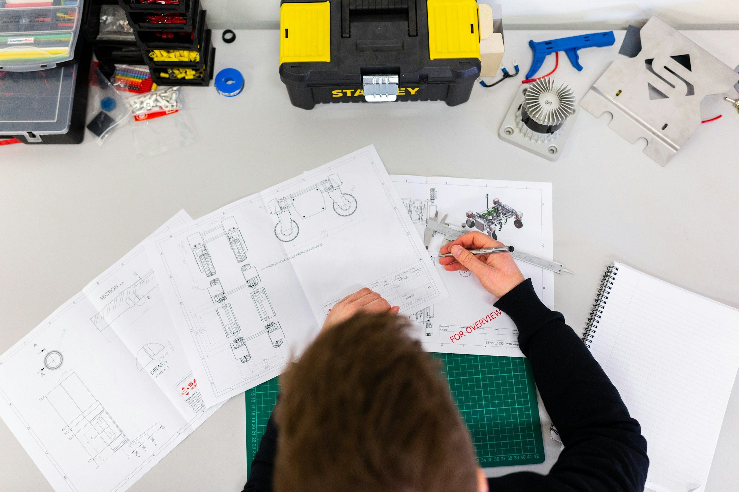 Profissional analisando desenhos técnicos sobre uma mesa