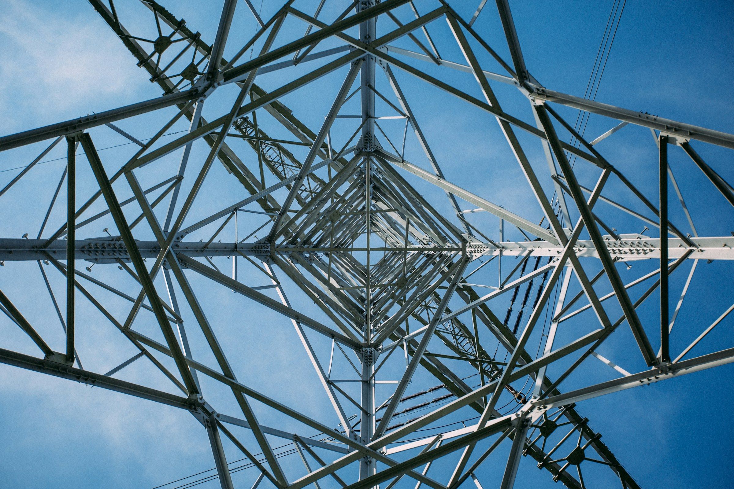 Estrutura metálica de uma torre de transmissão vista de baixo